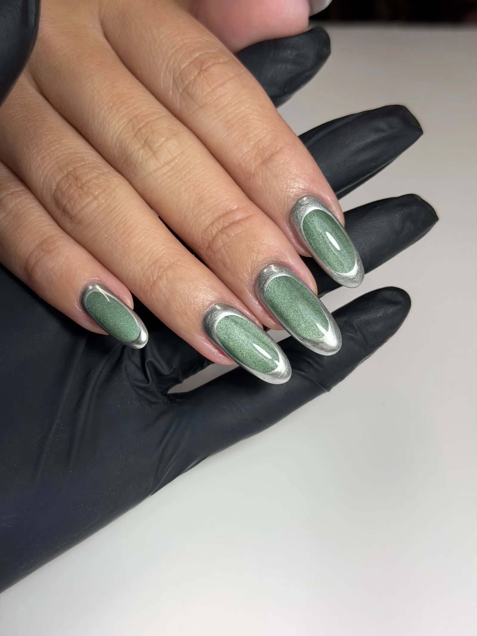 Sage green chrome cat eye manicure on long almond nails
