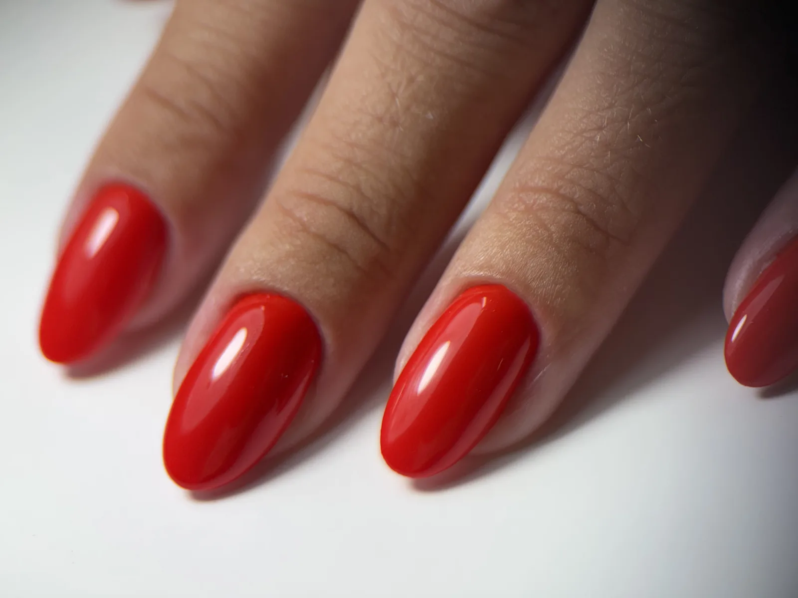 Close-up of glossy red gel with a precise cuticle line