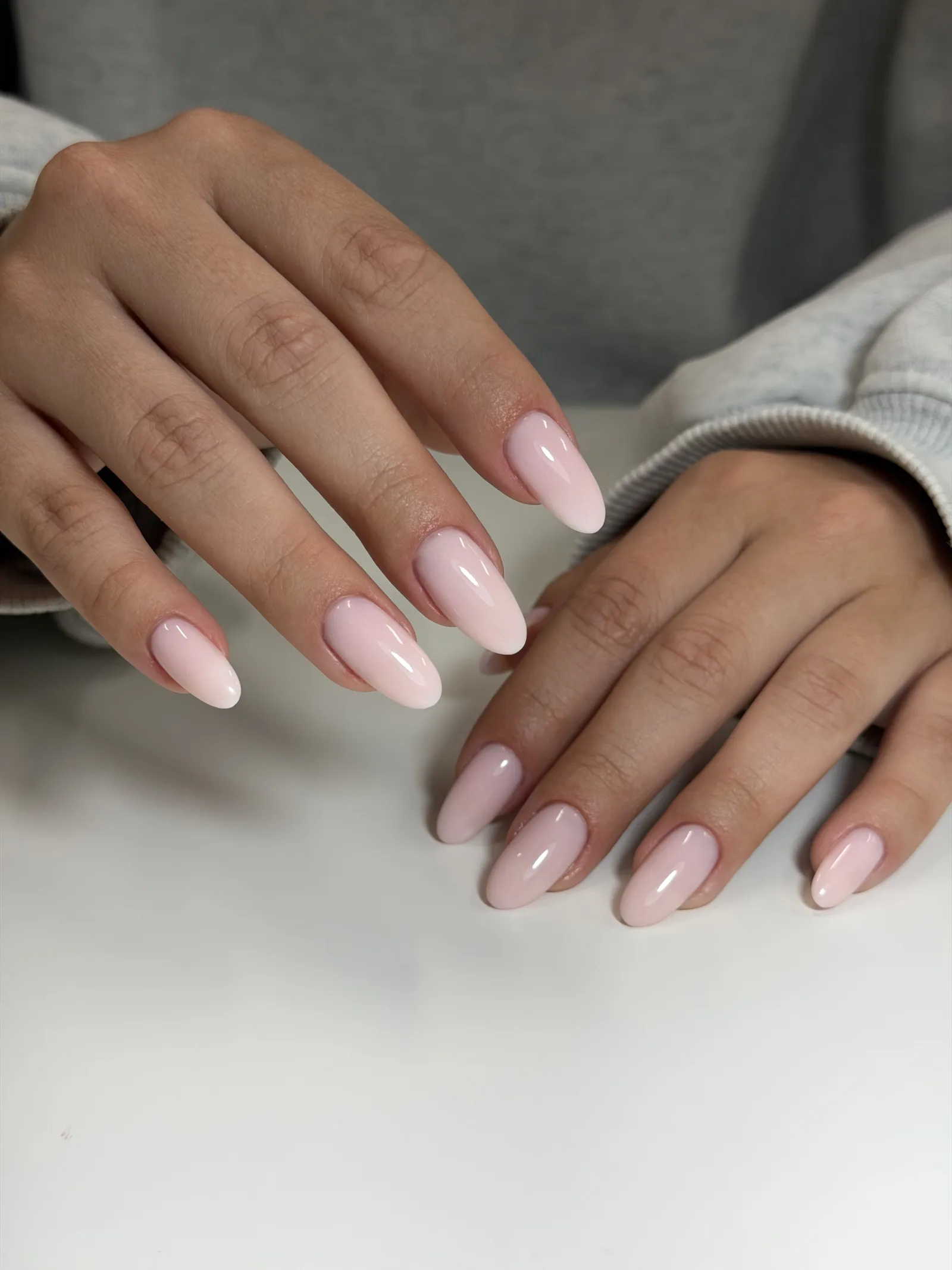 Sheer pink Russian manicure on almond nails, both hands